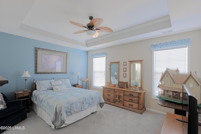 carpeted bedroom with ceiling fan, a raised ceiling, and multiple windows