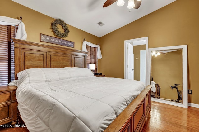 bedroom featuring visible vents, baseboards, light wood-style floors, lofted ceiling, and ceiling fan