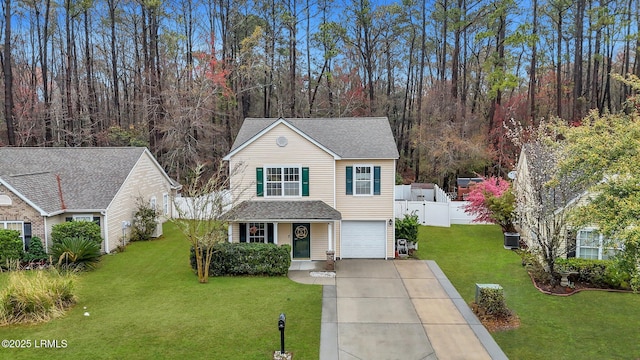 traditional-style home featuring fence, an attached garage, a shingled roof, concrete driveway, and a front lawn