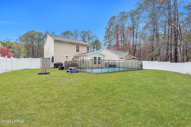 rear view of property featuring a yard, a fenced in pool, and a fenced backyard