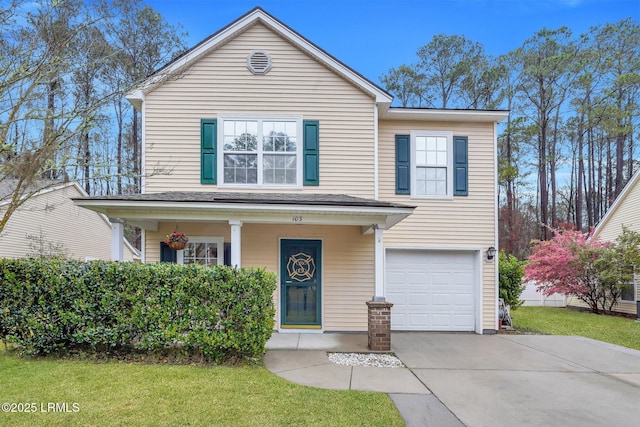 traditional-style house with covered porch, an attached garage, driveway, and a front yard