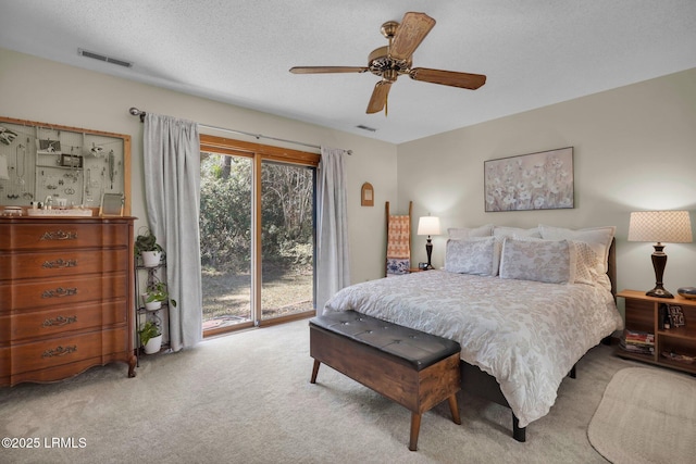 bedroom with a ceiling fan, visible vents, a textured ceiling, access to outside, and carpet flooring