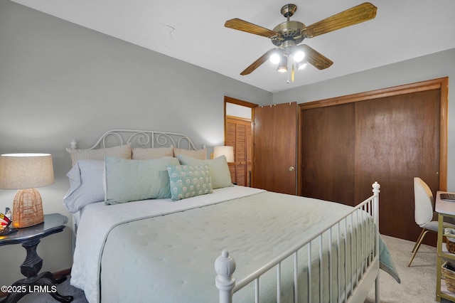 bedroom featuring a ceiling fan, a closet, and light carpet