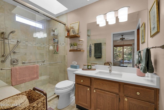 full bathroom featuring toilet, a shower stall, a skylight, and vanity