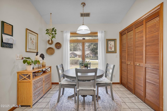 dining room featuring lofted ceiling, light tile patterned floors, baseboards, and visible vents