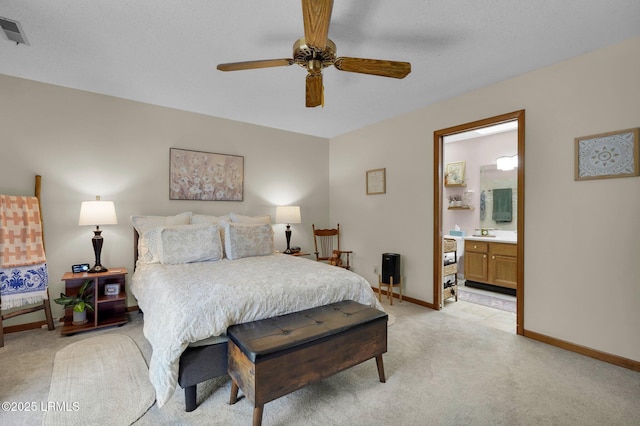 bedroom with connected bathroom, light colored carpet, visible vents, and baseboards