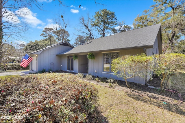 view of front of home featuring driveway, a garage, and roof with shingles