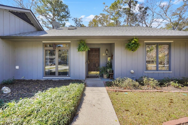 property entrance featuring board and batten siding and roof with shingles