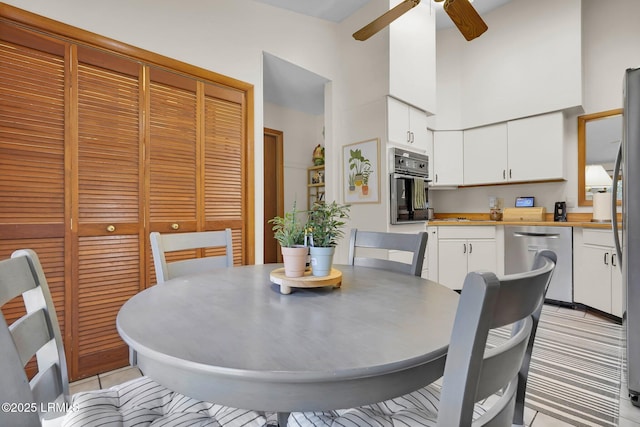 dining area featuring a high ceiling and ceiling fan