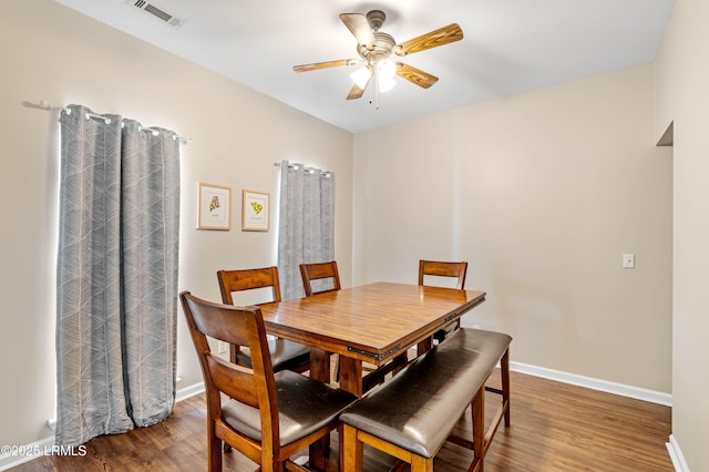 dining room featuring visible vents, ceiling fan, baseboards, and wood finished floors