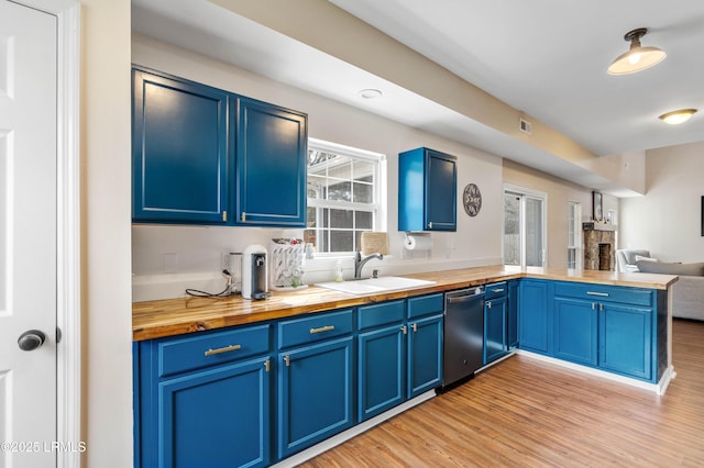 kitchen with blue cabinets, dishwasher, and wood counters