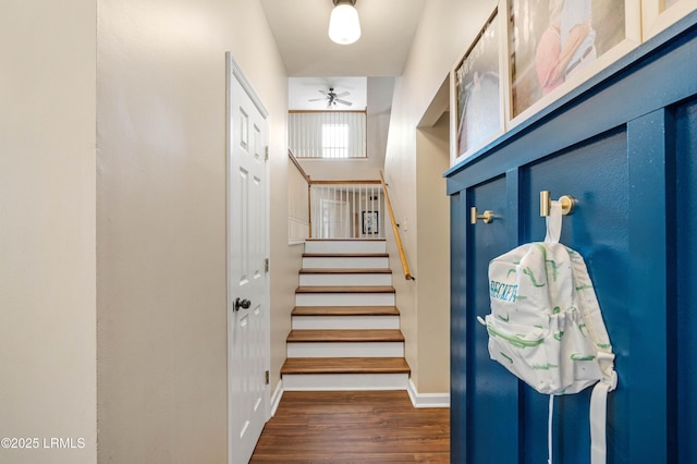 interior space featuring baseboards, stairway, and wood finished floors