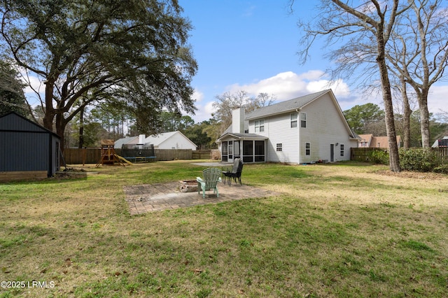 view of yard with a sunroom, a playground, a patio, and a fenced backyard