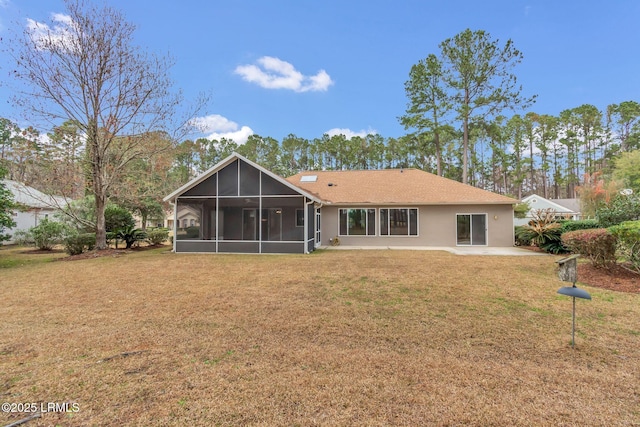 rear view of property with a yard, a patio area, and a sunroom