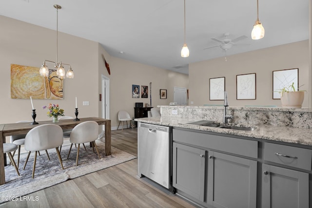 kitchen featuring pendant lighting, sink, gray cabinets, light hardwood / wood-style flooring, and stainless steel dishwasher