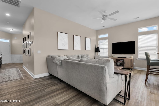 living room featuring dark wood-type flooring and ceiling fan