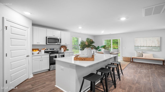 1595 Sanctum St, Ridgeland, SC 29936 - kitchen with stainless steel appliances, a kitchen bar, dark wood-type flooring, light countertops, and white cabinetry