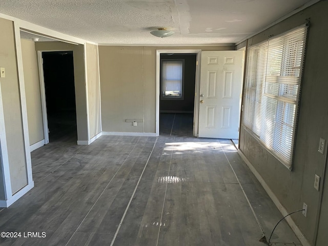 spare room with dark hardwood / wood-style floors and a textured ceiling