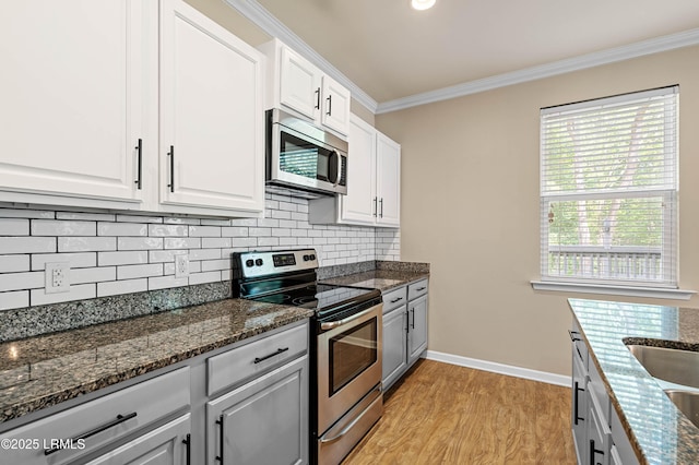 4944 Tidal Walk Ln, Beaufort, SC 29907 - kitchen with stainless steel appliances, ornamental molding, light wood finished floors, decorative backsplash, and white cabinetry