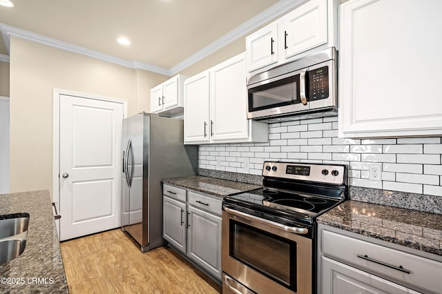 4944 Tidal Walk Ln, Beaufort, SC 29907 - kitchen featuring stainless steel appliances, crown molding, light wood-style floors, white cabinetry, and tasteful backsplash