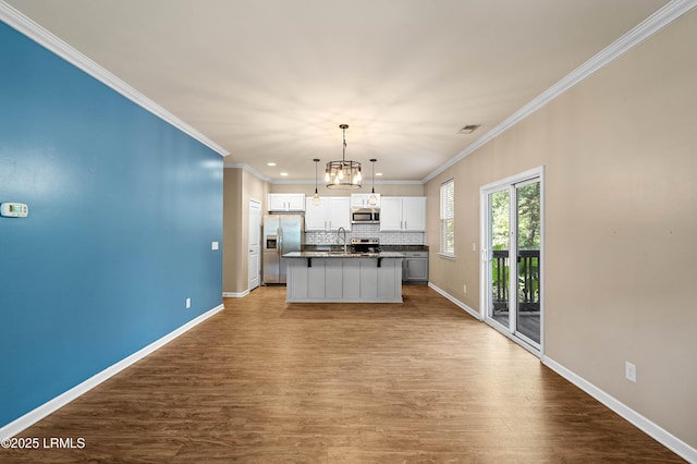 4944 Tidal Walk Ln, Beaufort, SC 29907 - kitchen featuring appliances with stainless steel finishes, white cabinets, wood finished floors, tasteful backsplash, and ornamental molding