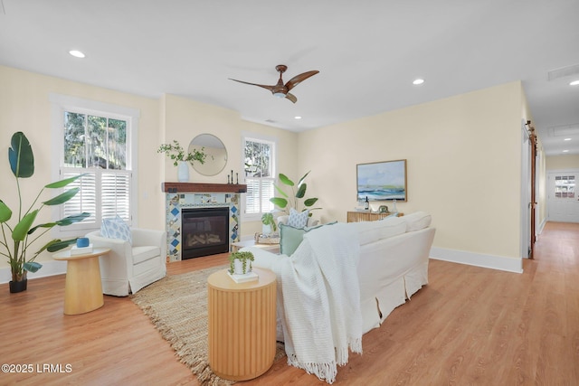 living room featuring a fireplace, a ceiling fan, wood finished floors, and recessed lighting