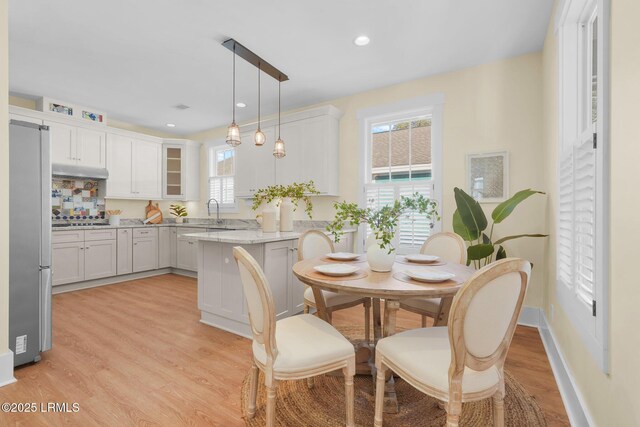 dining room featuring recessed lighting, baseboards, and light wood finished floors