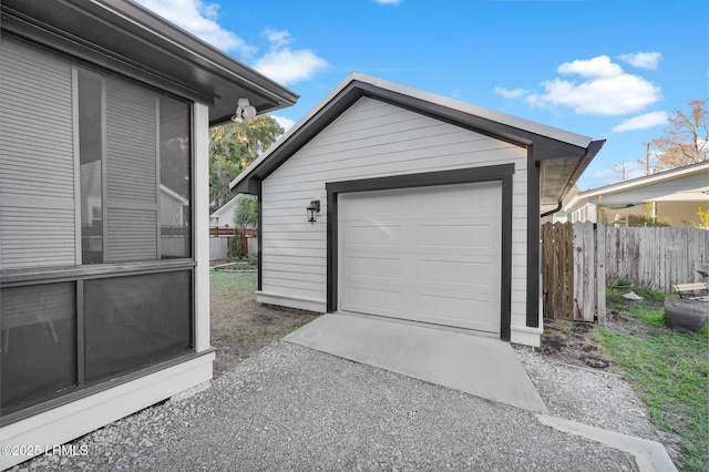 detached garage with driveway and fence