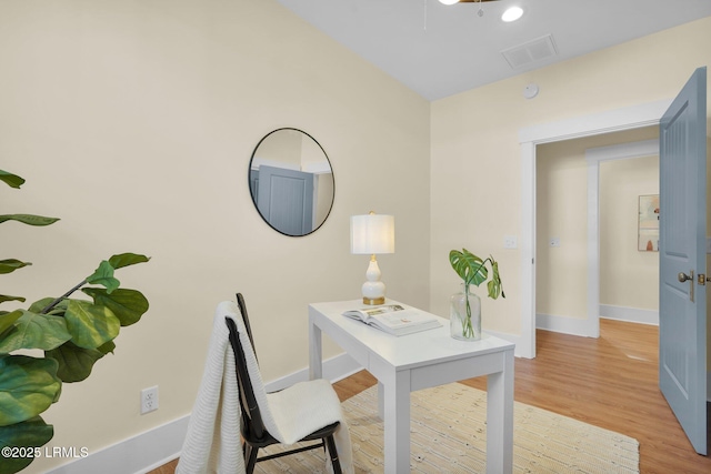 office area with baseboards, visible vents, and light wood-style floors