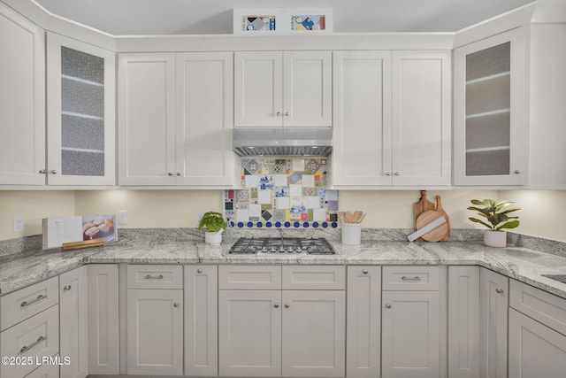 kitchen with white cabinets, stainless steel gas stovetop, and extractor fan