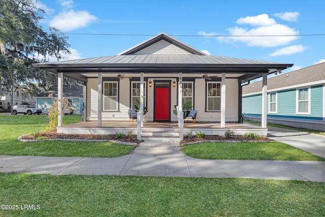 view of front of home with metal roof, a porch, a ceiling fan, a standing seam roof, and a front yard