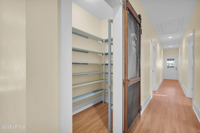 hallway with recessed lighting, wood finished floors, and baseboards