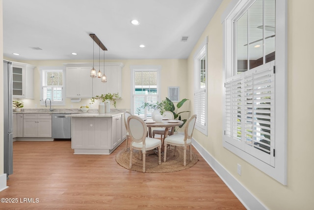 dining room featuring baseboards, recessed lighting, a wealth of natural light, and light wood-style floors