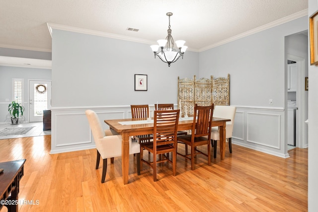 dining room featuring an inviting chandelier, crown molding, and light hardwood / wood-style floors