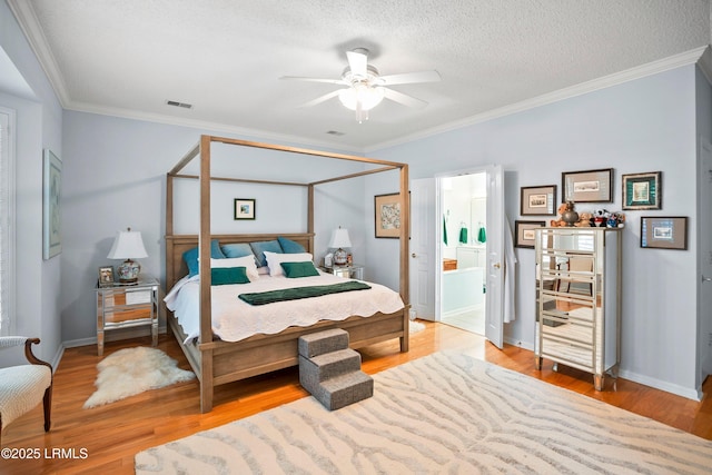 bedroom with crown molding, ensuite bathroom, a textured ceiling, and light hardwood / wood-style flooring