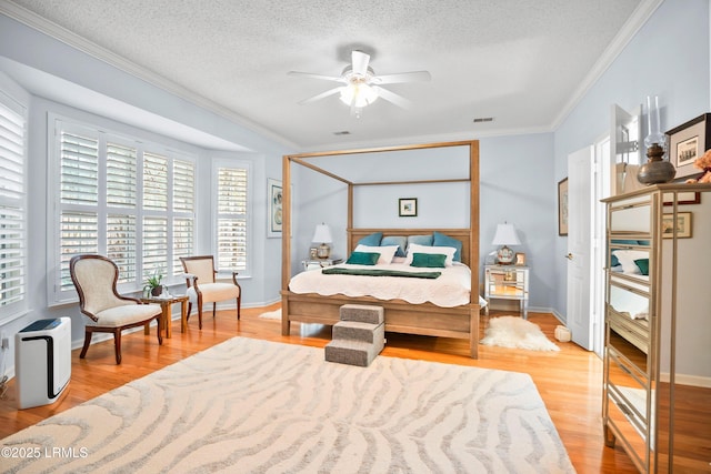 bedroom featuring crown molding, ceiling fan, a textured ceiling, and light wood-type flooring