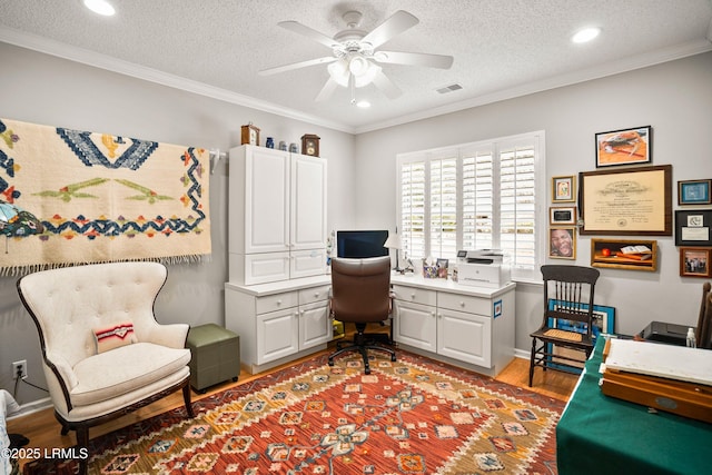 office featuring hardwood / wood-style flooring, ornamental molding, ceiling fan, and a textured ceiling