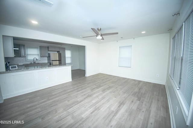 unfurnished living room with recessed lighting, a ceiling fan, light wood finished floors, and visible vents