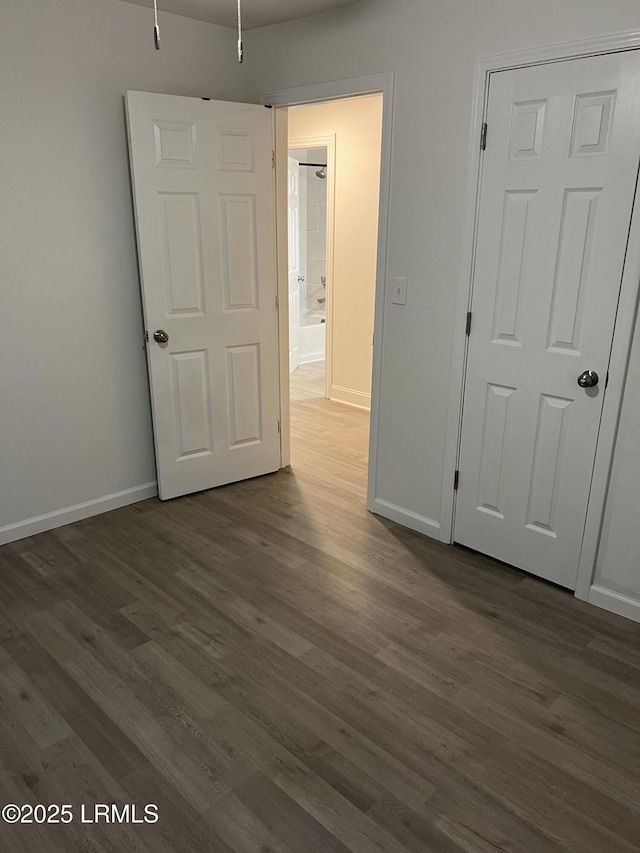 unfurnished bedroom with dark wood-type flooring