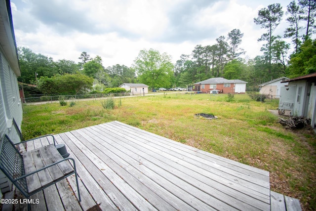 wooden terrace featuring a fenced backyard and a yard