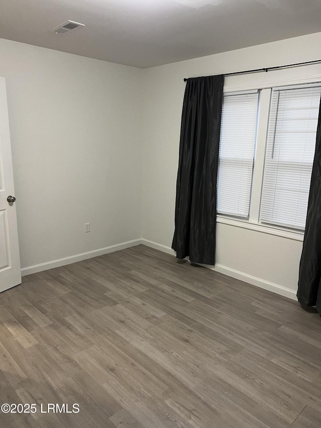 unfurnished room with dark hardwood / wood-style flooring