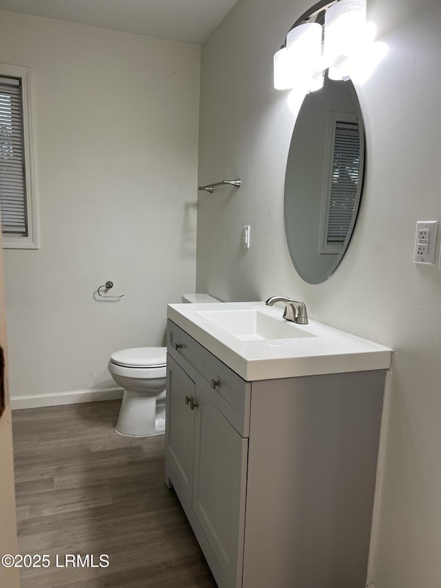 bathroom featuring hardwood / wood-style flooring, vanity, and toilet