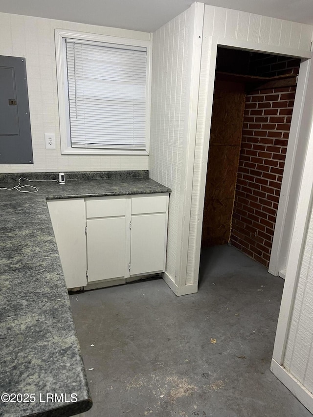 interior space with concrete flooring and electric panel