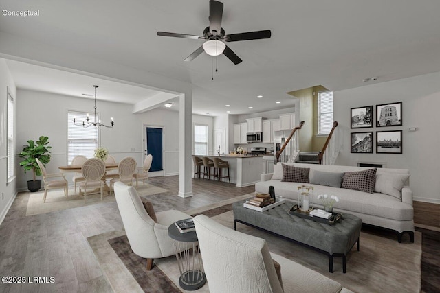 28 Kings Cross Ct, Beaufort, SC 29902 - living room with light wood-style flooring, a chandelier, baseboards, ceiling fan, and stairs