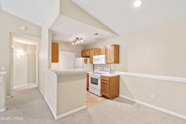 897 Fording Island Rd Unit 301, Bluffton, SC 29910 - kitchen with white appliances, lofted ceiling, light colored carpet, a peninsula, and baseboards