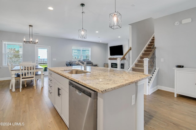 kitchen featuring dishwasher, pendant lighting, sink, and a center island with sink