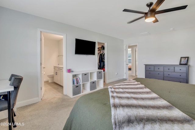 carpeted bedroom featuring ceiling fan, connected bathroom, a closet, and a walk in closet