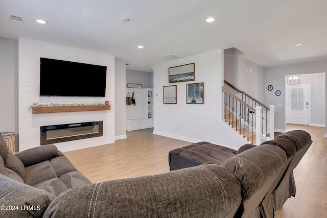 living room featuring a large fireplace and light wood-type flooring