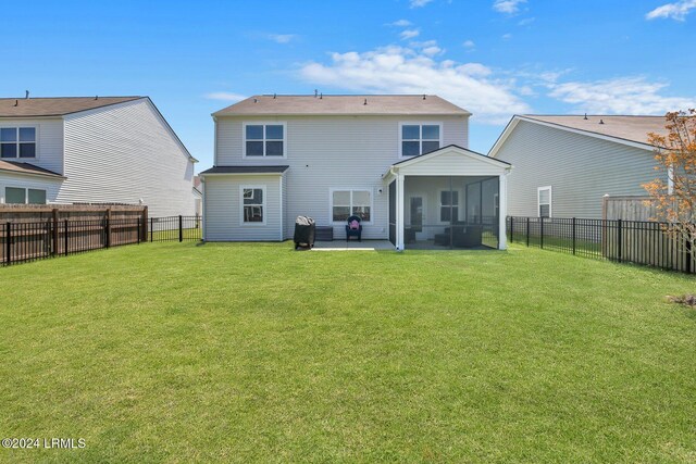 back of house with a sunroom, a yard, and a patio area