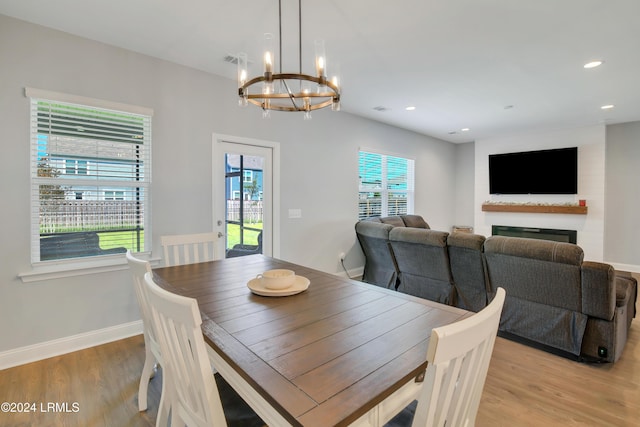 dining space with a large fireplace and light hardwood / wood-style flooring